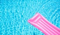 Beach summer holiday background. Inflatable air mattress on swimming pool water. Pink lilo and summertime accessories on poolside Royalty Free Stock Photo