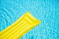 Beach summer holiday background. Inflatable air mattress on swimming pool water. Yellow lilo and summertime poolside