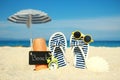 A Beach summer holiday banner background. Flip-flops and hat with a board and ball on the sand near the ocean. Summer accessories Royalty Free Stock Photo