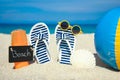 Beach summer holiday banner background. Flip-flops and hat with a board and ball on the sand near the ocean. Summer accessories on Royalty Free Stock Photo