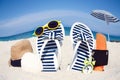 A Beach summer holiday banner background. Flip-flops and hat with a board and ball on the sand near the ocean. Summer accessories Royalty Free Stock Photo