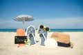 A Beach summer holiday banner background. Flip-flops and hat with a board and ball on the sand near the ocean. Summer accessories Royalty Free Stock Photo