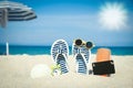 A Beach summer holiday banner background. Flip-flops and hat with a board and ball on the sand near the ocean. Summer accessories Royalty Free Stock Photo