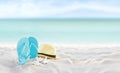 Beach summer holiday banner background. Flip flops and hat on sand near ocean. Summertime accessories on seaside. Tropical Royalty Free Stock Photo