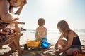 The beach, summers playground. an adorable little boy and girl playing with beach toys in the sand while their mother Royalty Free Stock Photo