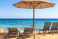 Beach with sunbeds and umbrellas against the background of the sea horizon. The bright blue sea. Snorkeling on the Red Sea in