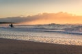 Beach sunrise seascape with surfer at the distance. Seaside summer background Royalty Free Stock Photo