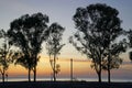 Beach at sunset. Bright colorful sky and silhouettes of pines and eucalyptus trees. Coastline. Evening in September.