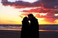 Beach, sunset and couple silhouette kiss in nature with love, freedom and romance outdoors. Shadow, romantic and people Royalty Free Stock Photo