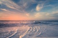 Beach sunset. Empty sand beach, sea waves, and sun setting down the horizon. blue and pink colors Royalty Free Stock Photo