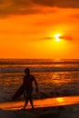Beach sunset surfer man surfing lifestyle relaxing holding surfboard looking at ocean waves for surf. Active healthy Royalty Free Stock Photo
