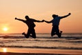 Beach sunset, shadow silhouette and couple jump, holding hands and having fun, bonding and enjoy nature freedom. Sky Royalty Free Stock Photo