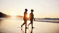 Beach sunset, silhouette and couple walking, holding hands and enjoy romantic conversation, freedom and travel holiday Royalty Free Stock Photo