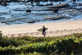 Surfer Walking Beach Rocks Vegetation Royalty Free Stock Photo