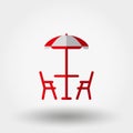 Beach table under an umbrella and chairs.
