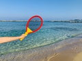 Beach tennis racquet in female hand on beach