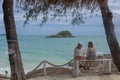 Two Women sitting and watch over the sea with backgound of sea