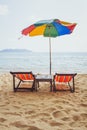 Beach in Thailand, two deck chairs and colorful umbrella Royalty Free Stock Photo