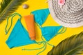 Beach theme on the yellow background. Sunscreen, hat, palm leaves, swimsuit  on the yellow background Royalty Free Stock Photo