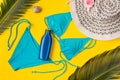 Beach theme on the yellow background. Sunscreen, hat, palm leaves, swimsuit  on the yellow background Royalty Free Stock Photo