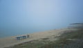 End of The land on the beach with a bench and a canopy