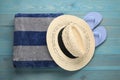 Beach towel, flip flops and straw hat on light blue wooden background, flat lay Royalty Free Stock Photo