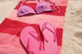 Beach towel with slippers and swimsuit on sand Royalty Free Stock Photo