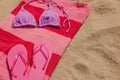 Beach towel with slippers and swimsuit on sand, space for text Royalty Free Stock Photo