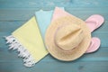 Beach towel, straw hat and flip flops on light blue wooden background, flat lay Royalty Free Stock Photo