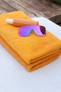 Beach towels, sunglasses and sunscreen on sunbed at resort