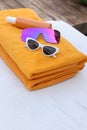 Beach towels, sunglasses and sunscreen on sunbed at resort