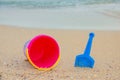 Beach toys on sand. Bright bucket, shovel on the sand