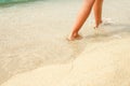 A Beach travel - woman relaxing walking on a sandy beach leaving footprints in the sand. Close up detail of female feet on golden Royalty Free Stock Photo