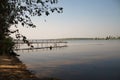 A beach with trees and a pier in the distance Royalty Free Stock Photo