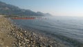 Beach in Turkey with transparent sea, pebbles and mountains in the background.