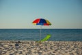 Beach umbrella and chair on the background of the sea Royalty Free Stock Photo