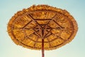 Beach umbrella made of straw against the blue sky