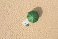 Beach umbrella near towel and other vacationist`s stuff on sand, aerial view Royalty Free Stock Photo