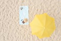 Beach umbrella near towel and other vacationist`s stuff on sand, aerial view Royalty Free Stock Photo