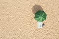 Beach umbrella near towel and other vacationist`s stuff on sand, aerial view. Space for text Royalty Free Stock Photo