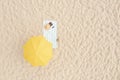 Beach umbrella near towel and other vacationist`s stuff on sand, aerial view. Space for text Royalty Free Stock Photo