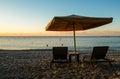 Beach umbrellas and relaxing chairs at sea at sunrise. Empty beach Pissouri Cyprus