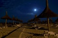 Beach umbrellas, sidewalk, full moon