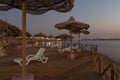 Beach umbrellas and sun loungers on the beach at dusk . Red sea. Royalty Free Stock Photo