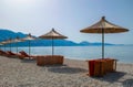 Beach umbrellas, and sun loungers on pebble beach. Qeparo village. Albania. Ionian Sea