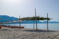 Beach umbrellas, and sun loungers on pebble beach. Qeparo village. Albania. Ionian Sea