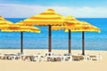 Beach umbrellas and sunbath seats on sand beach Royalty Free Stock Photo