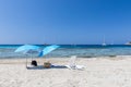 Beach umbrellas on white sand on the beautiful beach Ses Salines on the Ibiza island, Balearic Islands. Spain Royalty Free Stock Photo