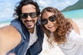 Beach vacation couple taking selfie photograph using smartphone relaxing and having fun holding smart phone camera. Young Royalty Free Stock Photo