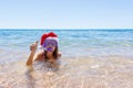 Beach vacation fun woman wearing a mask tube and christmas hat for swimming in ocean water. Close-up portrait of a girl in her tra Royalty Free Stock Photo